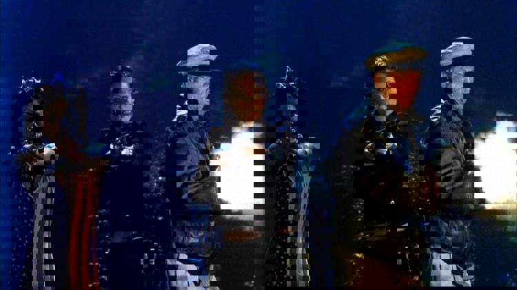 Three characters firing weapons in House of the Dead.