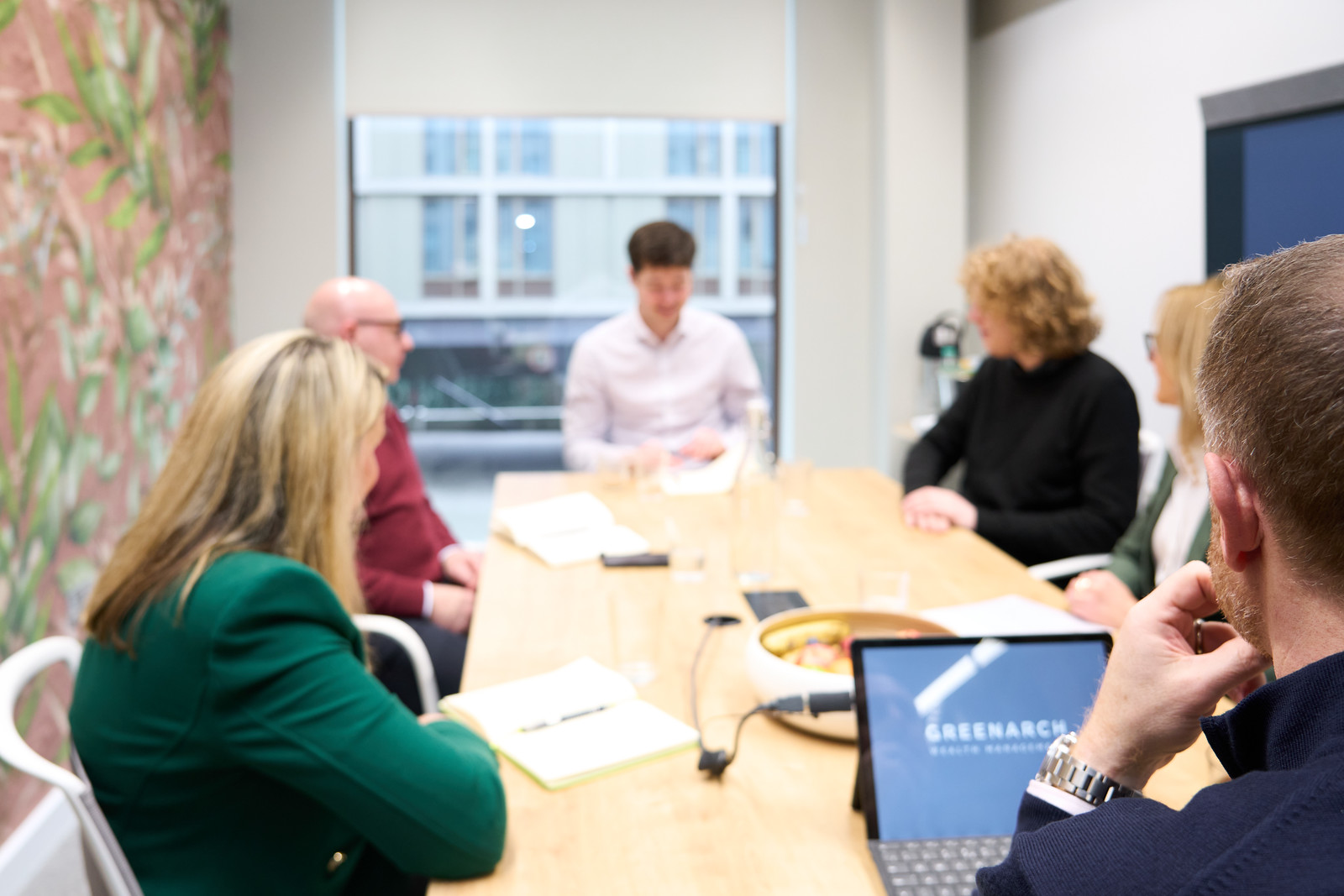 Business meeting at Greenarch Wealth Management with team members and laptops