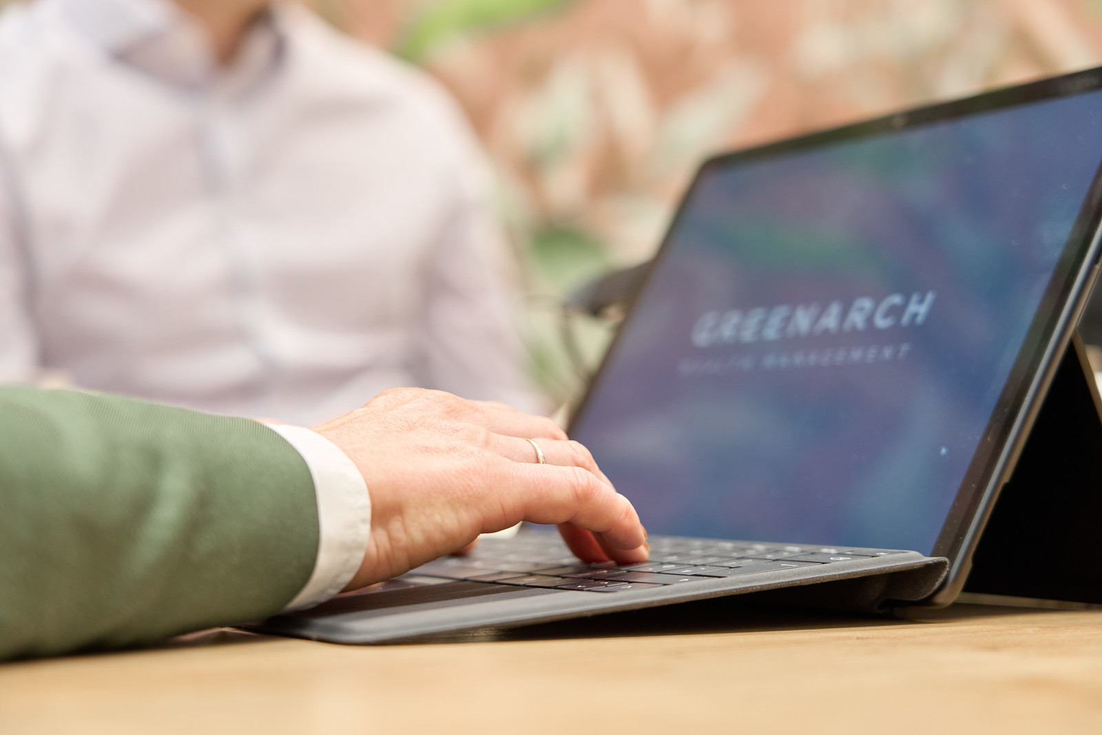 Close-up of a person typing on a laptop with Greenarch Wealth Management branding